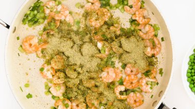 Kızartma tavasında karides soğan ve baharat karışımı, yukarıdan yakın görüş, beyaz arkaplan