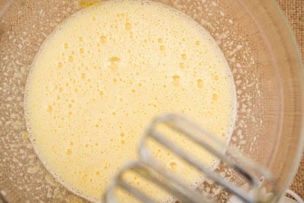 卵と砂糖のミックスをガラスボウルに入れ フラットレイアウトを閉じます 卵と砂糖を電動ミキサーで混ぜます ビスケットベースのレシピでアップルケーキ ステップバイステップのベーキングプロセス — ストック写真