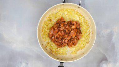 Kızarmış soğan ve tavada marine edilmiş tavuk filetosu, yukarıdan yakın görüş. Kırmızı biberli ekşi kremalı tavuk tarifi, adım adım pişirme işlemi.