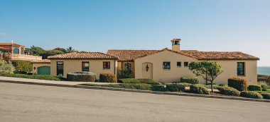 Bahçesi güzel manzaralı güzel evler ve Kaliforniya 'da küçük bir sahil kasabasında arka planda açık mavi gökyüzü..