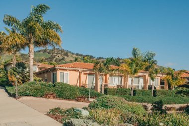 Bahçesi güzel manzaralı güzel evler ve Kaliforniya 'da küçük bir sahil kasabasında arka planda açık mavi gökyüzü..