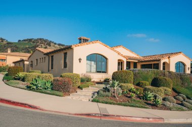 Bahçesi güzel manzaralı güzel evler ve Kaliforniya 'da küçük bir sahil kasabasında arka planda açık mavi gökyüzü..