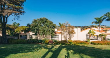 Bahçesi güzel manzaralı güzel evler ve Kaliforniya 'da küçük bir sahil kasabasında arka planda açık mavi gökyüzü..