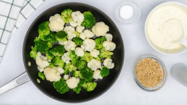 Karnabahar ve brokoli kızartma tavasında. Adım adım sebze güveç tarifi. Malzemeler mutfak masasına kapanıyor.