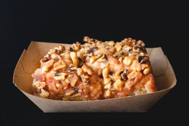 Ceviz şekerli tarçınlı rulo siyah arka planda yakın çekim