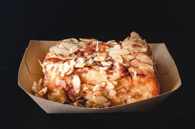 Badem şekerli tarçınlı rulo siyah arkaplana yaklaş