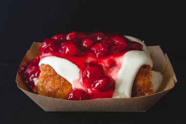 Kiraz şekerli tarçınlı rulo siyah arka planda yakın çekim