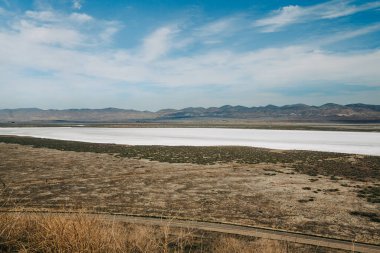 Carrizo Plain Ulusal Anıtı, San Luis Obispo Bölgesi, Kaliforniya. Soda Gölü, yerel bitkiler, tepeler, dağlar ve bulutlu gökyüzü arka planıyla çöl