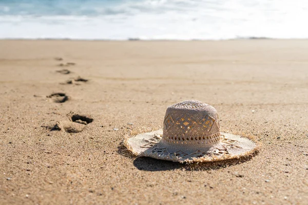 Der Strohhut Der Frau Auf Sand Strand Und Fußabdrücke Die — Stockfoto