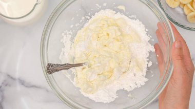 Krem peynir ve pudra şekeri cam bir kasede karıştırılmış, düz bir şekilde. Krem şanti peynirli tatlı tarifi