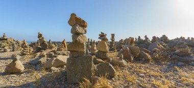 Kayalık sahildeki çakıl kuleleri ve mavi gökyüzü arka planı, Kaliforniya