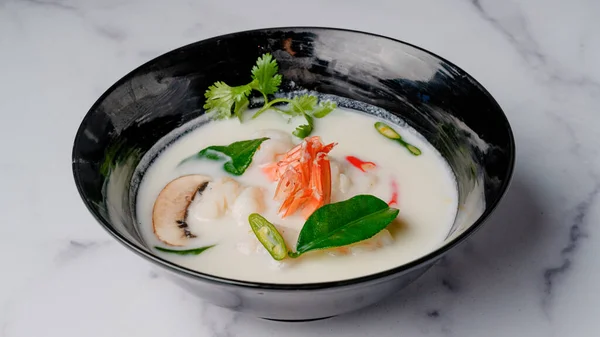 Kha coconut milk soup with shrimp. Traditional Chinese Thai restaurant soup close-up in a bowl