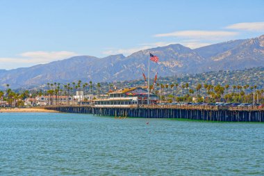 Santa Barbara, California, USA - August 1, 2022  Santa Barbara wharf, ocean view, palm trees, mountains, and cloudy sky background