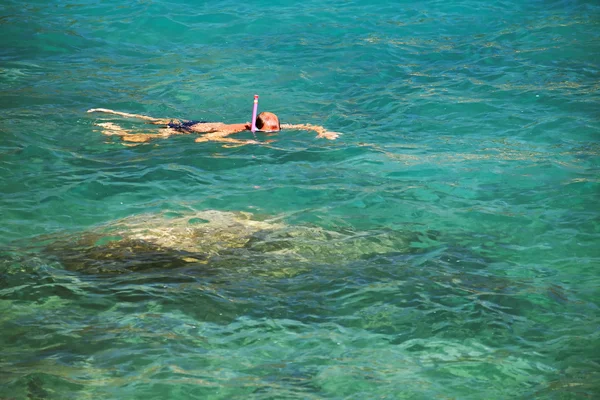 Man snorkeling over coral reef in transparent tropical sea — Stock Photo, Image