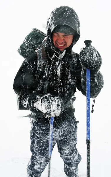 Alpinista enfrentando uma nevasca dura — Fotografia de Stock