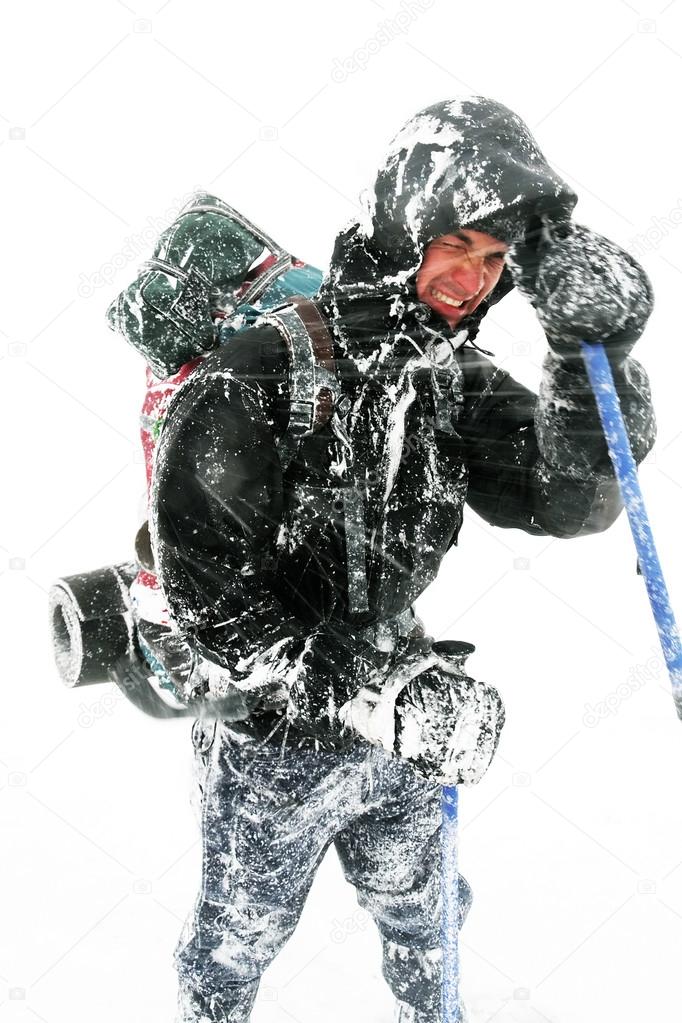Alpinist facing a harsh blizzard