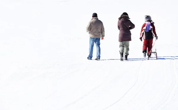 Padre tirando bambini in slitta attraverso paesaggio invernale — Foto Stock