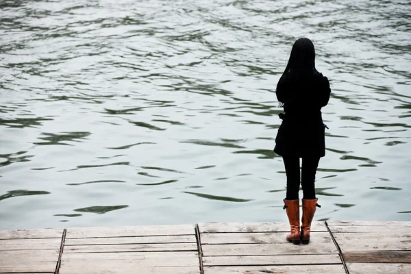 Mujer joven meditando en la orilla de un lago — Foto de Stock