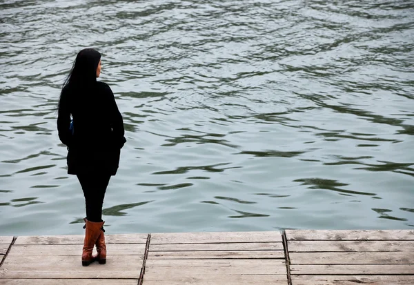 Νεαρή γυναίκα διαλογισμό στην ακτή μιας λίμνης — Φωτογραφία Αρχείου
