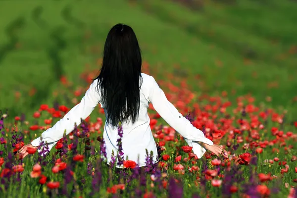 Young brunette beautiful girl enjoying the spring flowers — Stock Photo, Image