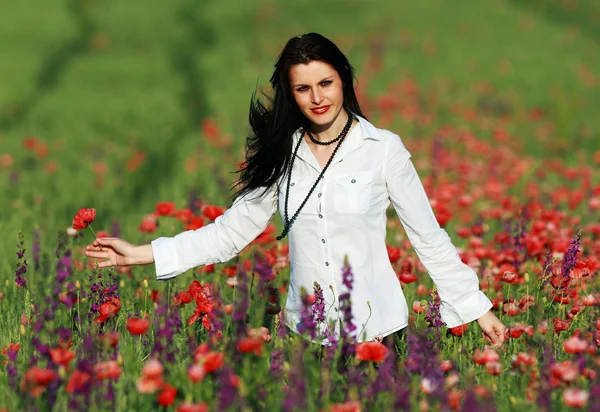 Young brunette beautiful girl enjoying the spring flowers — Stock Photo, Image