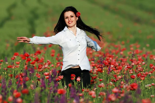 Young brunette beautiful girl enjoying the spring flowers — Stock Photo, Image