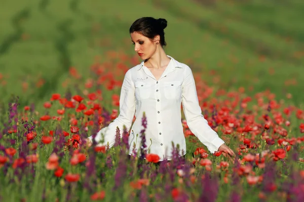 Young brunette beautiful girl enjoying the spring flowers — Stock Photo, Image