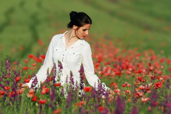 Young brunette beautiful girl enjoying the spring flowers — Stock Photo, Image