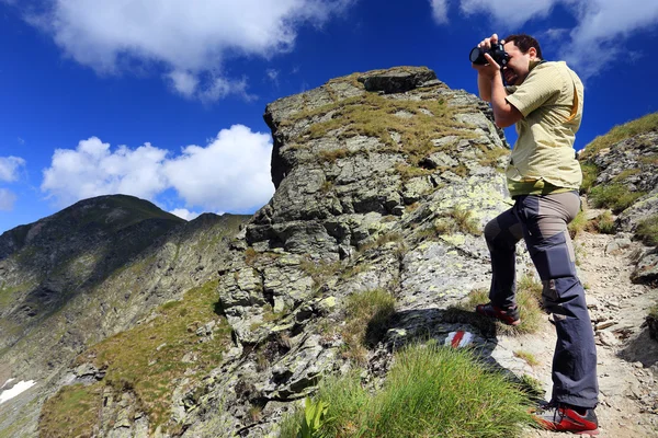Fotógrafo de la naturaleza tomando fotos en las montañas —  Fotos de Stock