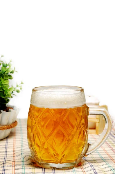 白い背景のパブやカフェのテーブルの上に軽いビールのマグカップ — ストック写真