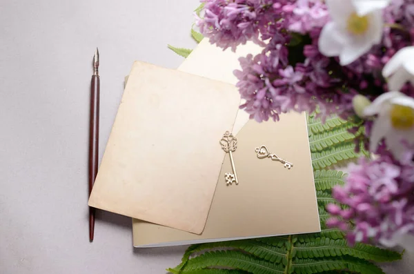 Romantische achtergrond met lila bloemen en notebook, schetsboek of dagboek — Stockfoto