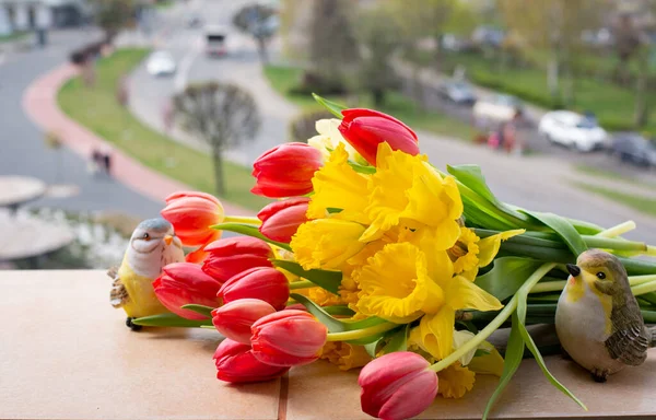 Kırmızı laleler ve Sarı Narcissus güzel bir bahar buketinde. Bahar Çiçeği Kasaba Manzarasına Karşı Bir Pencerede
