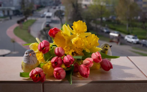 Kırmızı laleler ve Sarı Narcissus güzel bir bahar buketinde. Şehir Manzarasına Karşı Pencere Üzerine Bahar Çiçeği