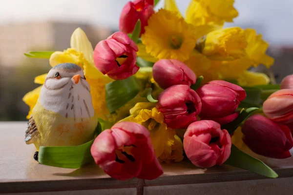 Kırmızı laleler ve Sarı Narcissus güzel bir bahar buketinde. Şehir Manzarasına Karşı Pencere Üzerine Bahar Çiçeği