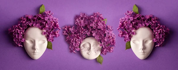 Plaster women faces, figurine decorated with lilac flowers. Lilac as a hairstyle on the head against velvet violet background. Womens day concept.