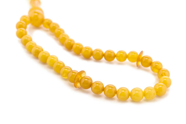 Балтийское ожерелье из натурального полированного прозрачного меда роскошные янтарные бусины с включениями на белом. Закрыть избирательный мягкий фокус. Пространство для текста