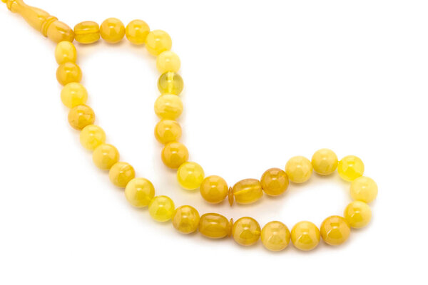 Балтийское ожерелье из натурального полированного прозрачного меда роскошные янтарные бусины с включениями на белом. Закрыть избирательный мягкий фокус. Пространство для текста
