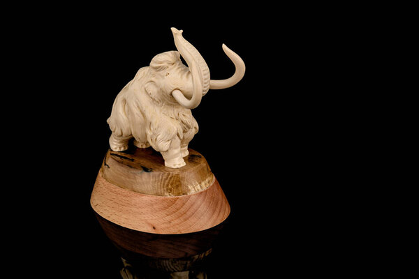 ivory statuette of elephant mammoth on black background