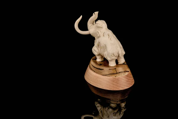 Estatueta de marfim de mamute elefante sobre fundo preto — Fotografia de Stock