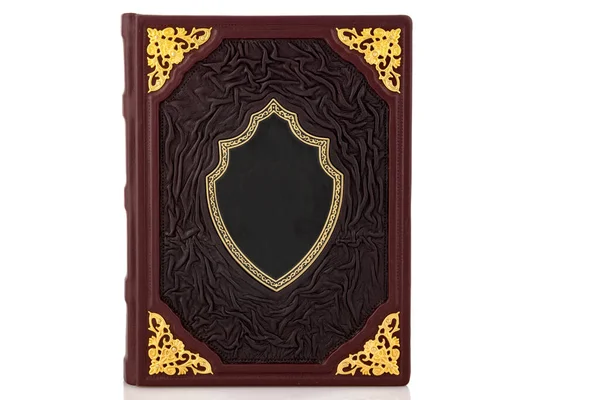 Beyaz arka planda izole edilmiş, kapak rengi olan kırmızı kahverengi deri deri derili bir kitap. Boş kepçe ve metal takılarla.