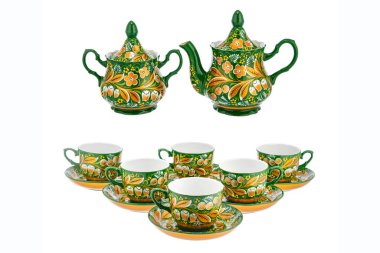 Geleneksel Rus halk aletlerinden oluşan yeşil altın çay seti. Beyaz arkaplanda el yapımı Khokhloma tarzı çiçek süsü bulunan tabaklar.