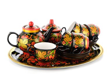 Geleneksel Rus halk aletlerinden oluşan altın sarısı kırmızı çay seti. Beyaz arkaplanda el yapımı Khokhloma tarzı çiçek süsü bulunan tabaklar.