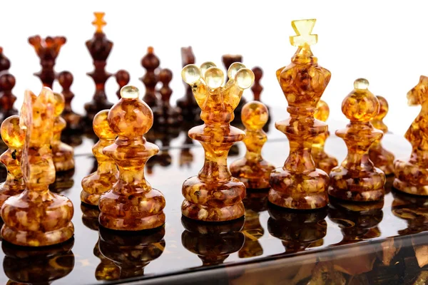 Natürlicher Bernstein verschiedene Schachfiguren stehen auf lackiertem Brett — Stockfoto