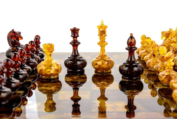 Natural amber different chess pieces figures standing on lacquer surface board — Stock Photo, Image