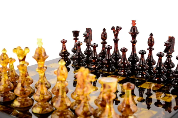 Φυσικό κεχριμπάρι διαφορετικές μορφές σκακιού στέκεται σε λάκα επιφάνεια του σκάφους — Φωτογραφία Αρχείου