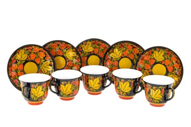 Bir çift eski geleneksel Rus halk oyuncağı seti. Tabak tabağı ve fincanda beyaz arka planda izole edilmiş Khokhloma tarzı el yapımı çiçek süsü var..