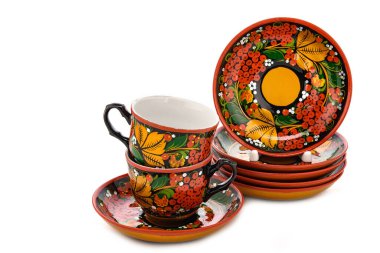 Bir çift Eski Geleneksel Rus halk oyuncakları. Tabak tabağı ve fincanda beyaz arka planda izole edilmiş Khokhloma tarzı el yapımı çiçek süsü var..