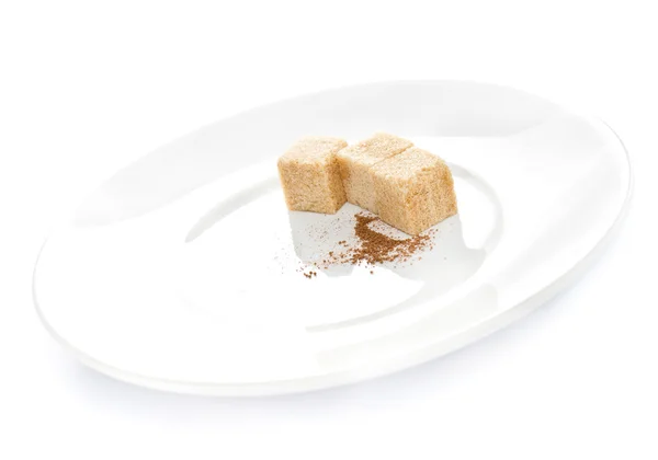 Nád kocka cukor és a csokoládé por fehér háttérben a tányéron — Stock Fotó