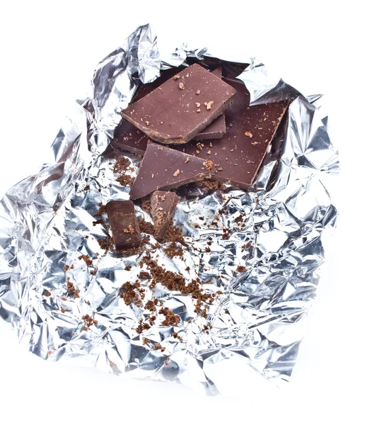 Κομμάτια σοκολάτας τσαλακωμένο σε αλουμινόχαρτο σε άσπρο φόντο — Φωτογραφία Αρχείου
