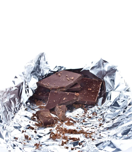 Κομμάτια σοκολάτας τσαλακωμένο σε αλουμινόχαρτο σε άσπρο φόντο — Φωτογραφία Αρχείου